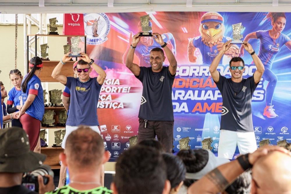 Campeões erguendo os troféus no pódio